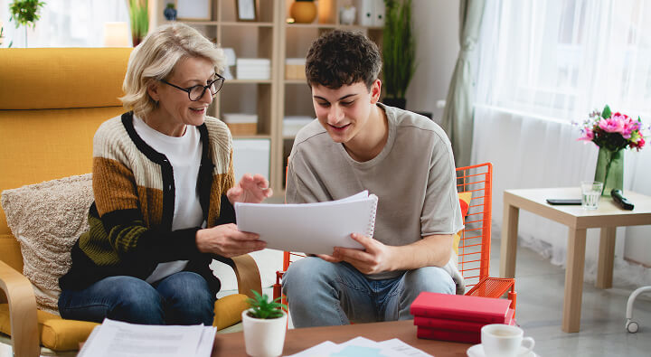 A mother and son reading some paperwork and smiling
