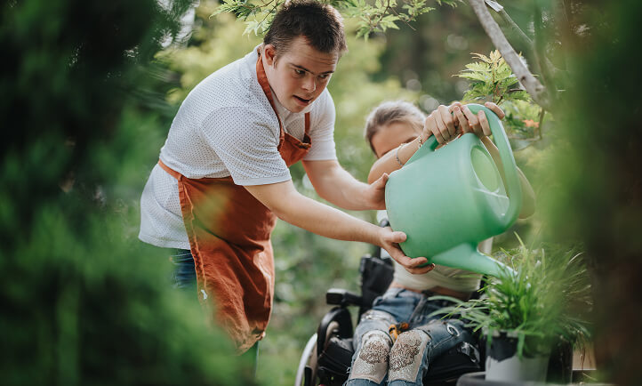 A teenage boy using a watering can